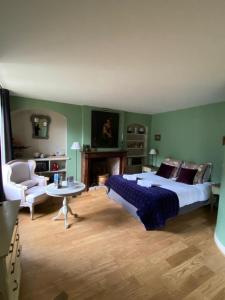 a bedroom with a large bed and a fireplace at La Cour Sainte Catherine demeure de charme in Honfleur