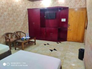 a living room with a red cabinet and a table at Hotel Royal Avenue in Chittagong