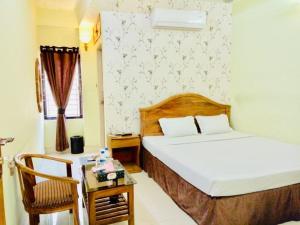 a bedroom with a bed and a table and a chair at Hotel Royal Avenue in Chittagong +11 photos