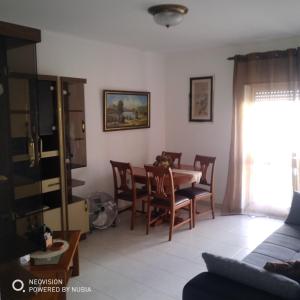 Apartamento Central في فيلا ريال دي سانتو انطونيو: غرفة معيشة مع طاولة طعام وكراسي