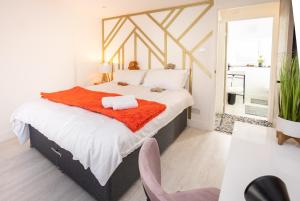 1 dormitorio con 1 cama grande con manta naranja en James' Place at Castle Cottage, en Merthyr Tydfil