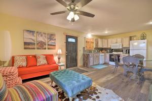 a living room with a red couch and a kitchen at Vibrant Home about 7 Mi to Fort Worth Stockyards! in Fort Worth