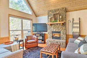a living room with a stone fireplace in a house at Idyllic Creekside Bryson City Gem with Fire Pit! in Bryson City