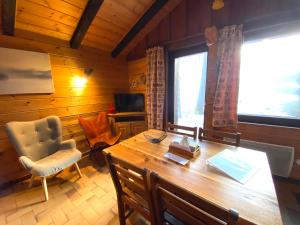 een kamer met een houten tafel en stoelen en een bureau bij LE FLOCON 1 Appartement avec terrasse in La Bresse