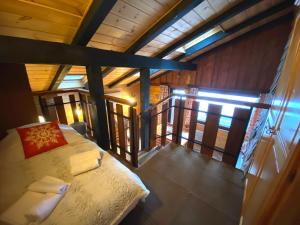 een zolderkamer met een bed en een balkon bij LE FLOCON 1 Appartement avec terrasse in La Bresse