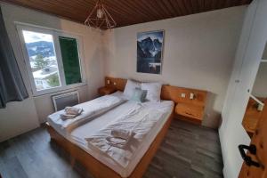 a bedroom with a large bed with two towels on it at Cozy chalet apartment near hiking trail and ski lift in Oberiberg