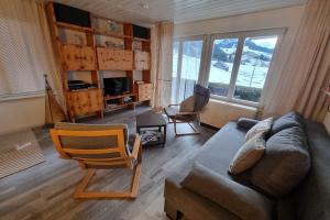 a living room with a couch and a chair at Cozy chalet apartment near hiking trail and ski lift in Oberiberg