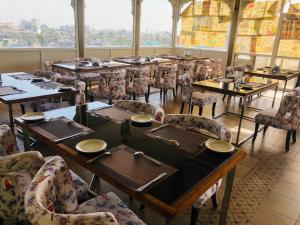a dining room with tables and chairs and windows at Hotel Ratangarh Palace in Jaipur