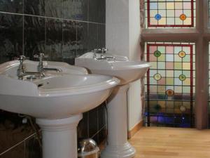 a bathroom with two sinks and stained glass windows at The Silk House in Leek