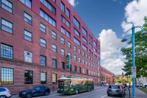 a green bus driving down a street in front of a building at The Suites Hotel at Waterfront Plaza in Duluth