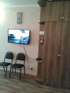 a room with two chairs and a flat screen tv at Orbi Plaza Apartment in Batumi