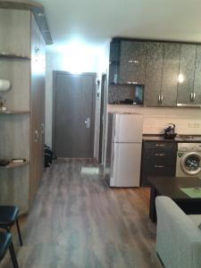 a small kitchen with a white refrigerator and a table at Orbi Plaza Apartment in Batumi