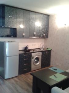 cocina con nevera y lavadora en Orbi Plaza Apartment en Batumi