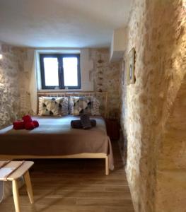 um quarto com uma cama numa parede de pedra em Vassili's House em Roústika