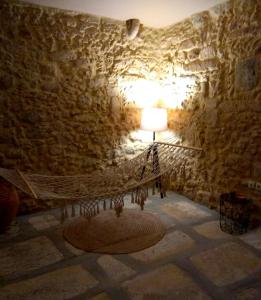 um quarto com uma rede de descanso numa parede de pedra em Vassili's House em Roústika