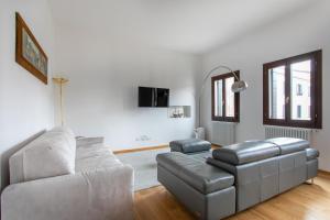 ein Wohnzimmer mit einem Sofa und einem Stuhl in der Unterkunft Residenza Pomponi Deluxe in Venedig