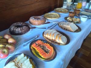 einen Tisch mit vielen verschiedenen Lebensmitteln in der Unterkunft Pousada Essência Serrana Gramado in Gramado