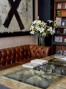 un sofá de cuero con una mesa de cristal con flores. en Casa Carmen Reforma, en Oaxaca City