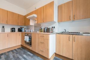 a kitchen with wooden cabinets and a sink at Lovely 2 Bedroom 3 Beds SOJ In Great Location Hull in Hull