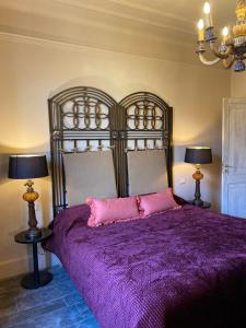 1 Schlafzimmer mit einem Bett mit einer lila Bettdecke und 2 Lampen in der Unterkunft La Didì Maison in Bologna