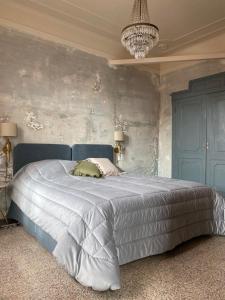 a bedroom with a large bed with a blue wall at La Didì Maison in Bologna