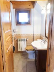 łazienka z toaletą, umywalką i oknem w obiekcie Casita de madera a Peu del Riu Incles - Sol y Nieve - Parking incluido w mieście Incles