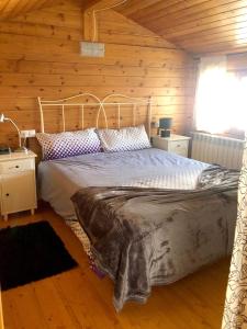 ein Schlafzimmer mit einem Bett in einer Holzhütte in der Unterkunft Casita de madera a Peu del Riu Incles - Sol y Nieve - Parking incluido in Incles