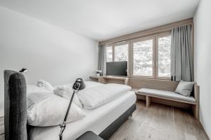 a bedroom with a bed and a window and a television at all inclusive Hotel Lohmann in Obergurgl