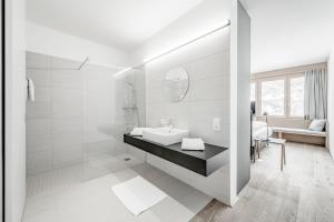 オーバーグルグルにあるオールインクルーシブ ホテル ローマンの白いバスルーム(シンク、鏡付)