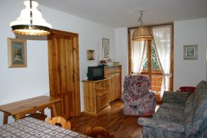 a living room with a couch and a tv at Residence Valfassa in Canazei