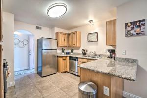 a kitchen with a stainless steel refrigerator and wooden cabinets at Seasonal Pool and Spa Las Vegas Pad, 11 Mi to Strip in Las Vegas