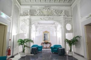Pokój z 2 niebieskimi krzesłami i lustrem w obiekcie Hotel Palazzo Benci we Florencji