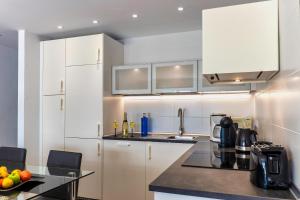 eine Küche mit weißen Schränken und einer schwarzen Arbeitsplatte in der Unterkunft N E W 2021 My-Lanza the Luxury ONE in Costa Teguise