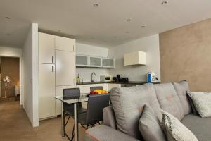 een woonkamer met een bank en een tafel en een keuken bij N E W 2021 My-Lanza the Luxury ONE in Costa Teguise
