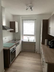 una cocina vacía con fregadero y ventana en Grenznahe Ferienwohnung mit 4 Schlafzimmern, en Grenzach-Wyhlen