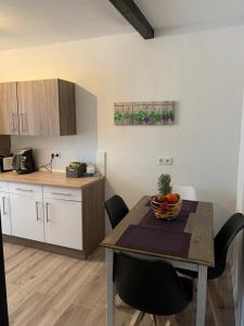 una cocina con una mesa con un bol de fruta. en Grenznahe Ferienwohnung mit 4 Schlafzimmern, en Grenzach-Wyhlen