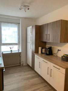a kitchen with a white refrigerator and a window at Grenznahe Ferienwohnung mit 4 Schlafzimmern in Grenzach-Wyhlen