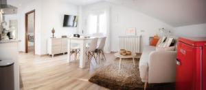 a white living room with a table and a couch at Casa Blanco Vista Maravillosa in Compostela