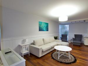 een woonkamer met een witte bank en een tafel bij Family Suite Parking 2 Bathrooms 300 m sea in Sopot