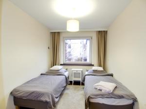 two beds in a room with a window at Family Suite Parking 2 Bathrooms 300 m sea in Sopot