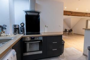 a kitchen with a stove top oven next to a sink at Magnifique appartement rénové dans résidence in Saumur