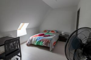 um quarto com uma cama, uma ventoinha e uma janela em Magnifique appartement rénové dans résidence em Saumur