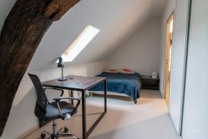 um quarto com uma secretária e uma cama no sótão em Magnifique appartement rénové dans résidence em Saumur