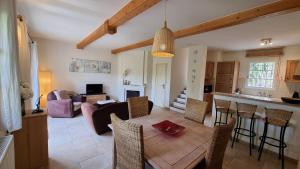 een keuken en een woonkamer met een tafel en stoelen bij Villa au golf de St-Endréol in La Motte