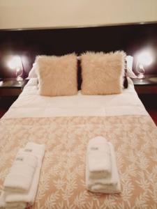 duże łóżko z dwoma białymi ręcznikami w obiekcie BairesTop con 2 dormitorios y estacionamiento w BuenosAires
