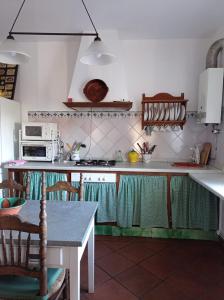 cocina con mesa y fogones horno superior en Casa rural La Vega, en Cazalla de la Sierra