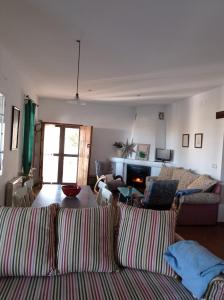 Sala de estar con 2 sofás y TV en Casa rural La Vega, en Cazalla de la Sierra