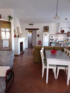 sala de estar con mesa y cocina en Casa rural La Vega, en Cazalla de la Sierra