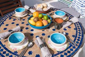 a table with blue plates and bowls of fruit on it at Casa Higueras in Moclín