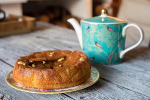 a bundt cake on a plate next to a cup at Casa Higueras in Moclín